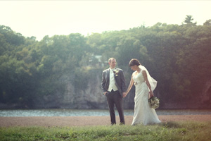 Bride and groom walking along Cedar River near Iowa City