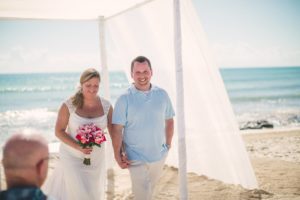 bride and groom about to walk down aisle after their beachside wedding