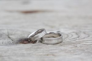 two white gold wedding bands stacked together on rustic wood