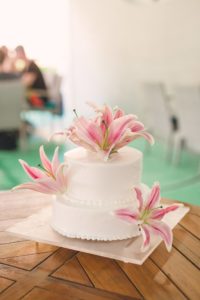 two-tiered wedding cake with tropical pink lilies