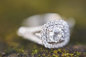 vintage-style diamond engagement ring on a mossy rock